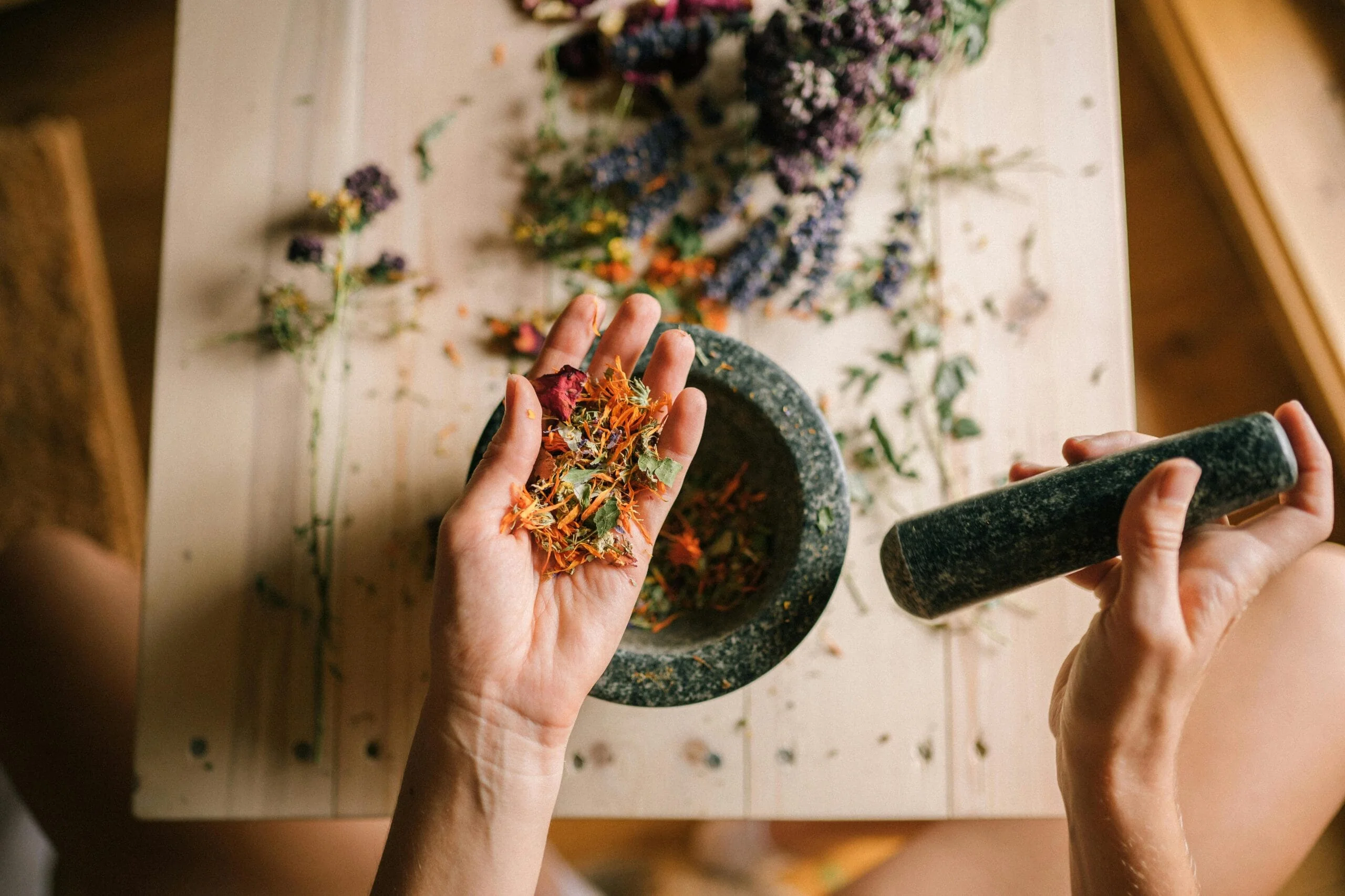 Hands preparing herbs for Mujer Raíz.