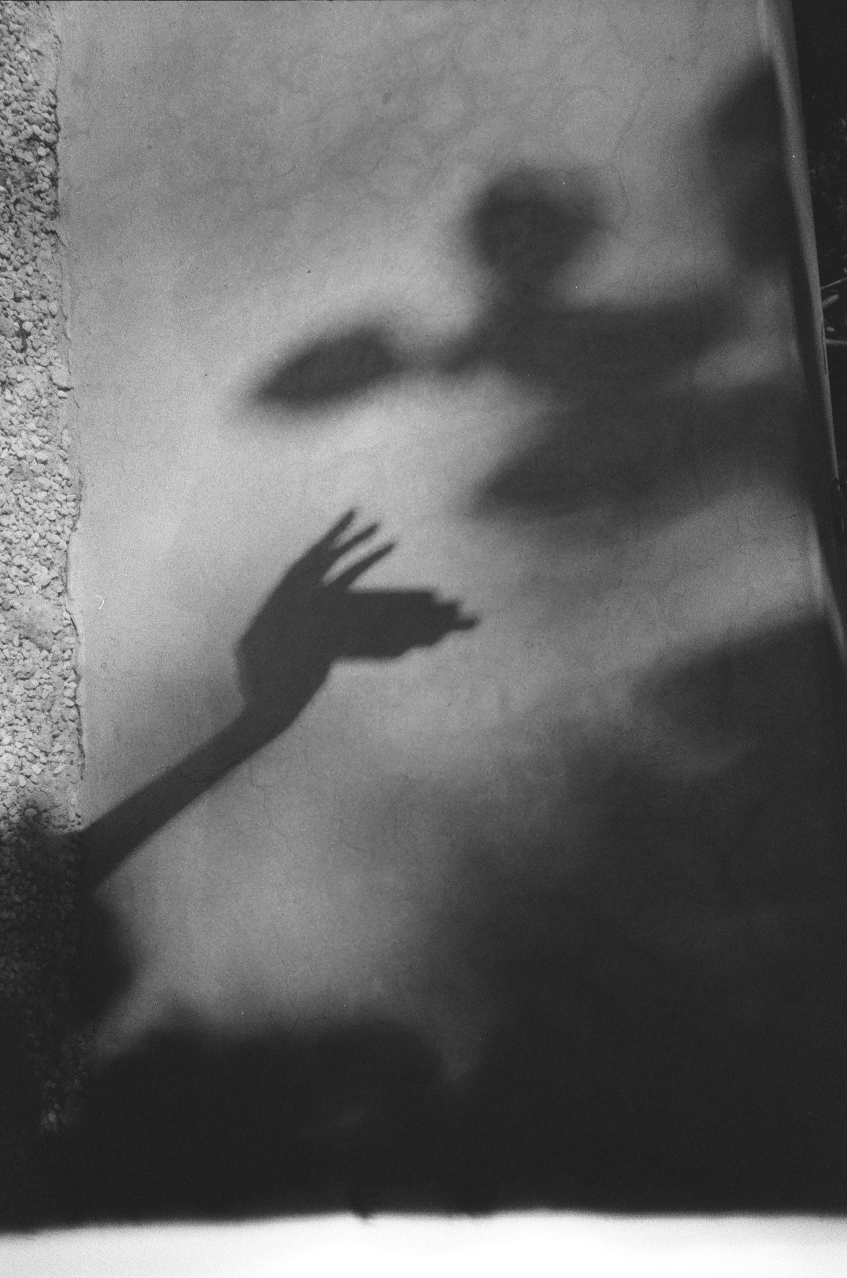 Shadow of a hand holding a Mukani jewelry piece.